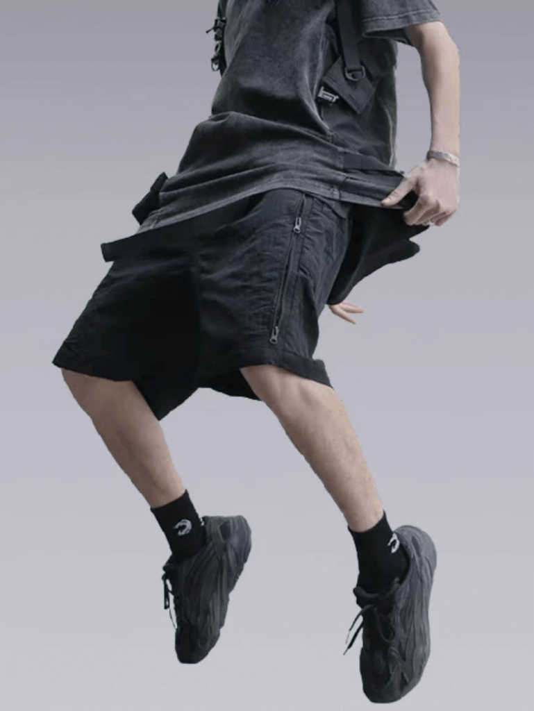 Man with dark grey shirt, techwear shorts and sneakers