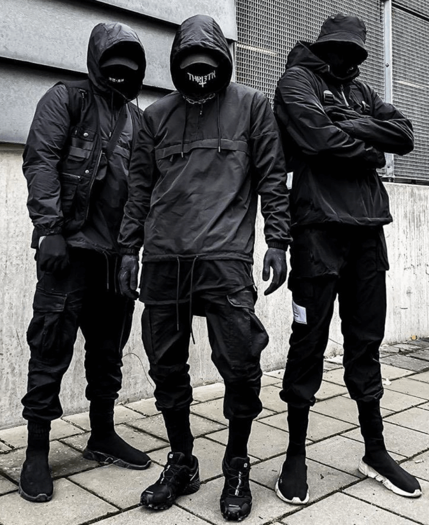 Three men wearing all black techwear outfits